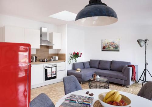 a living room with a couch and a table with a bowl of fruit at Elflein Quartier in Potsdam