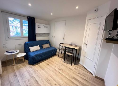 ein Wohnzimmer mit einem blauen Sofa und einem Tisch in der Unterkunft Menton Ciapetta in Menton