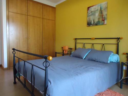 sypialnia z łóżkiem w żółtym pokoju w obiekcie House with pool CASA DA FAIA - AVEIRO (Estarreja) w mieście Avanca