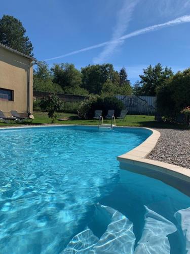 a swimming pool with blue water in a yard at Gite du Pavillon in Lens-Lestang