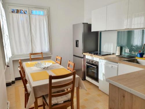 une cuisine avec une table et des chaises dans une cuisine dans l'établissement Villa Tassigny, à Aix-en-Provence