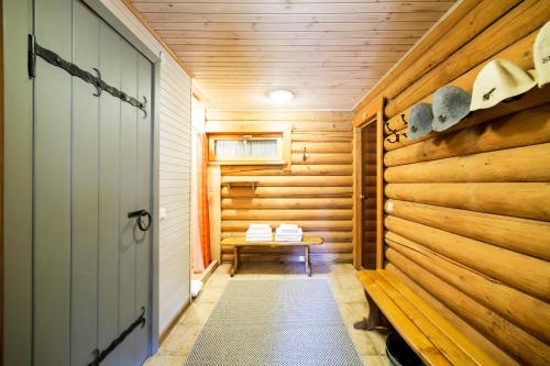 a sauna with a bench in a wooden wall at Rasos Vila in Palanga