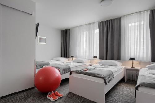 ein Zimmer mit 4 Betten und einem roten Ball darin in der Unterkunft Jantar Resort in Stettin