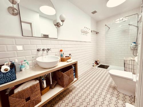 een badkamer met een wastafel, een toilet en een spiegel bij Luxury Bungalow Playa Roca in Costa Teguise
