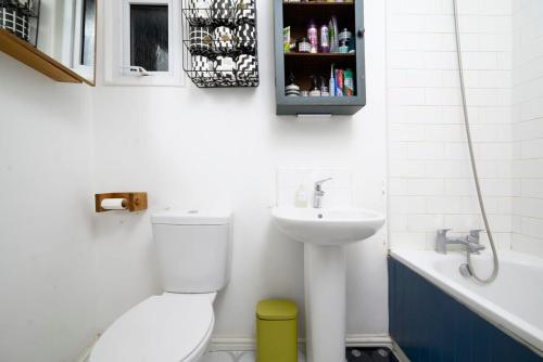 uma casa de banho com um WC e um lavatório em Charming 3BR Family-Friendly London Home em Londres