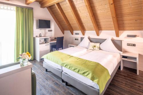 Dormitorio con cama, escritorio y TV en Adler Landhotel, en Buergstadt