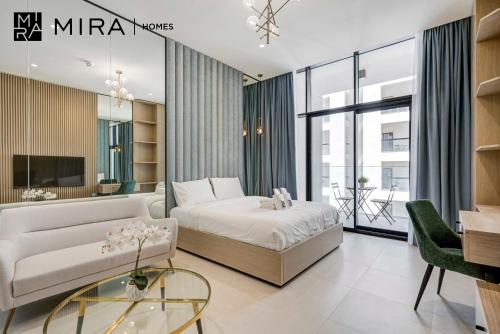 a bedroom with a bed and a couch and a table at Mira Holiday Homes-Cozy studio close to metro in Dubai