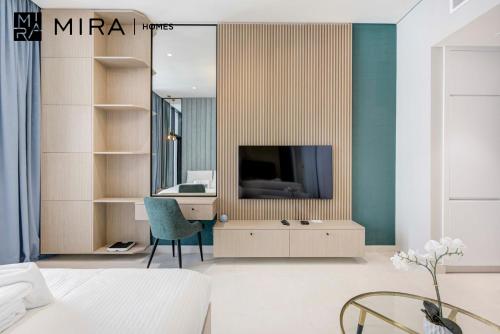 a bedroom with a tv and a desk with a chair at Mira Holiday Homes-Cozy studio close to metro in Dubai
