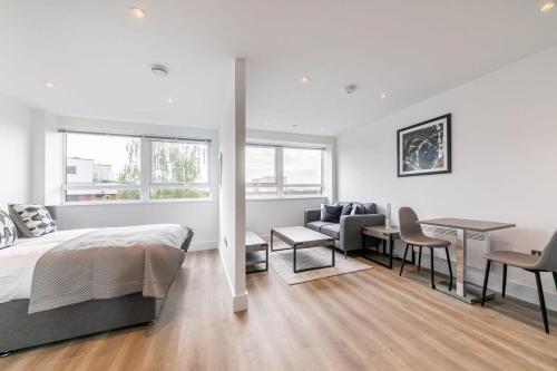 イースト・グリンステッドにあるBright and Modern Studio Apartment in East Grinsteadのベッドルーム1室(ベッド1台、テーブル付)、ダイニングルームが備わります。