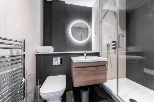 La salle de bains est pourvue de toilettes, d'un lavabo et d'une douche. dans l'établissement Bright and Modern Studio Apartment in East Grinstead, à East Grinstead