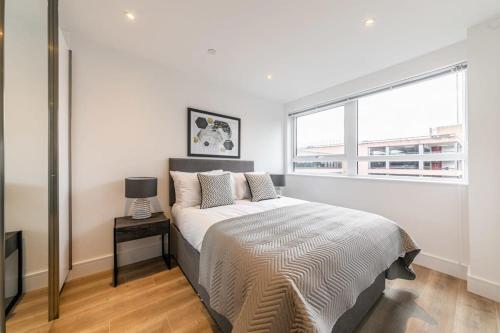 um quarto branco com uma cama e uma janela em Lovely Bright Studio Apartment in Central East Grinstead em East Grinstead