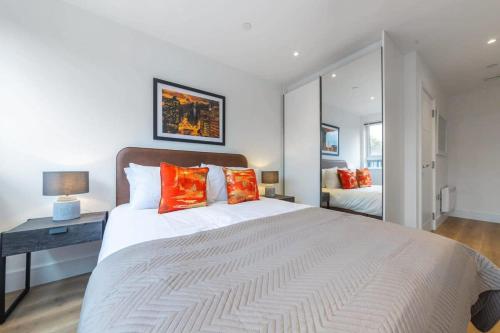 a bedroom with a large white bed with orange pillows at Contemporary Studio in Central East Grinstead in East Grinstead
