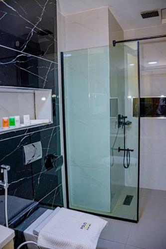 a bathroom with a shower with a glass door at Polo Grand Hotel in Maiduguri