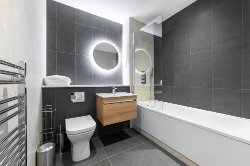 a bathroom with a toilet and a tub and a sink at Modern and Stylish Studio Apartment in East Grinstead in East Grinstead