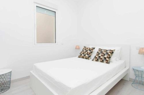 een witte kamer met een witte bank en een raam bij We Madrid Casa Arriaza in Madrid