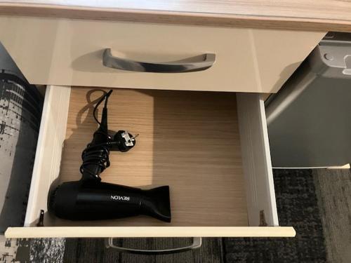 a black camera in a drawer of a desk at Private stay @ London-Stratford. in London