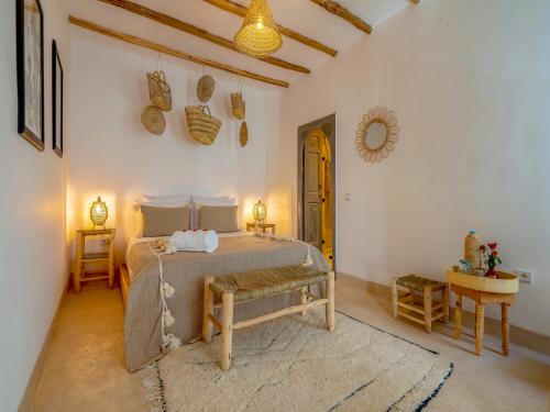 Schlafzimmer mit einem Bett, einem Tisch und einem Spiegel in der Unterkunft Riad Nelia De Marrakech Hotel Boutique & Spa in Marrakesch