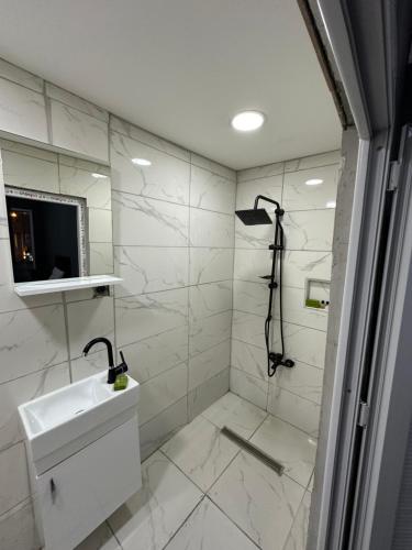a white bathroom with a sink and a shower at REYNA OTEL in Yıldırım