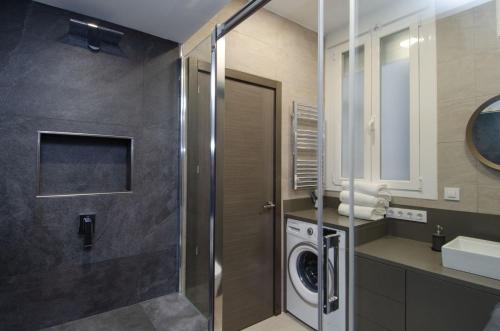 a bathroom with a washer and dryer in it at We Madrid Casa Duque in Madrid