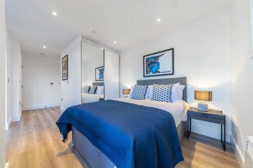 a bedroom with a large bed with a blue blanket at Modern Studio Apartment in East Grinstead in East Grinstead