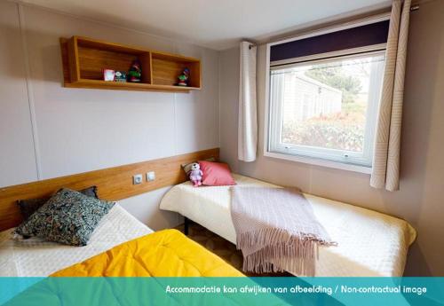 Habitación pequeña con 2 camas y ventana en Siblu camping Lauwersoog en Lauwersoog