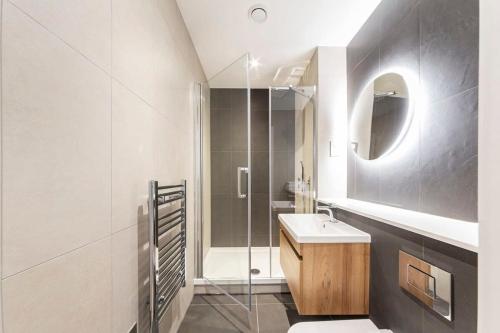 uma casa de banho com um lavatório e uma cabina de duche em vidro. em Modern and Stylish 1 Bed Apartment in East Grinstead em East Grinstead