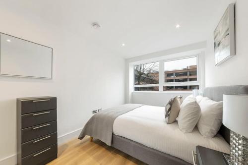 um quarto branco com uma cama e uma janela em Modern and Stylish 1 Bed Apartment in East Grinstead em East Grinstead