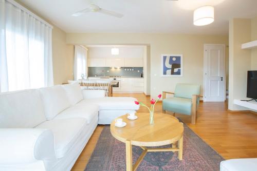 uma sala de estar com um sofá branco e uma mesa em boo premium living ioannina em Anatolí