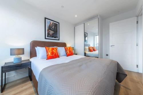 a bedroom with a large bed with orange pillows at Modern and Bright 1 Bed Apartment in East Grinstead in East Grinstead