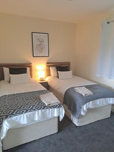 dwa łóżka siedzące obok siebie w sypialni w obiekcie Celtic Minor Stables w mieście Swansea