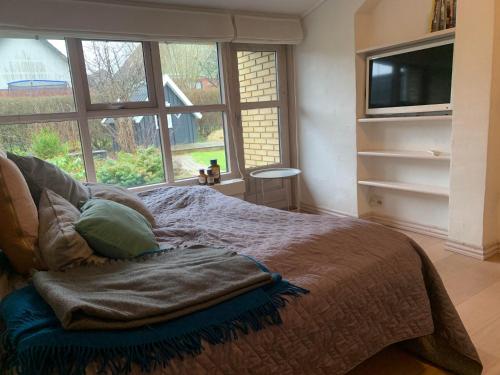 a bedroom with a bed with a large window at Spacious 3-bedroom house in Hjørring