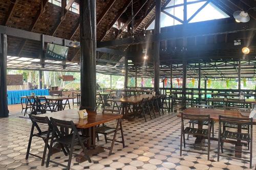 an empty restaurant with wooden tables and chairs at Phu Ing Fah Resort in Chiang Mai