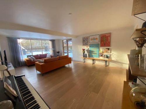 a living room with a couch and a piano at Spacious 3-bedroom house in Hjørring