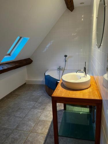 une salle de bain avec un lavabo sur une table en bois dans l'établissement Les Janets 12 personnes, à Saint-Sauveur-en-Puisaye