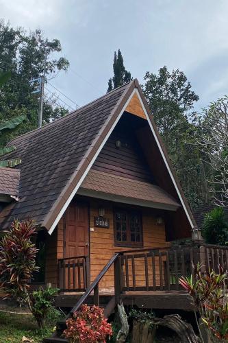 a log cabin with a roof and a porch at Phu Ing Fah Resort in Chiang Mai