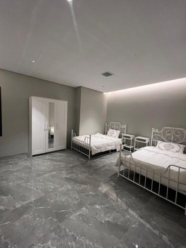 2 camas en una habitación con suelo de mármol en شاليه S.W الفندقي, en Buraidah
