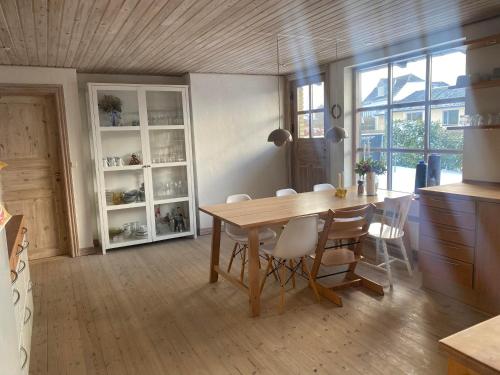 a dining room with a wooden table and chairs at Spacious 3-bedroom house in Hjørring