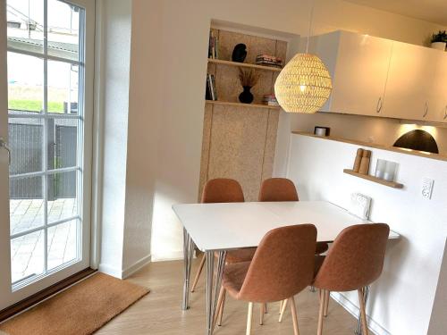 a dining room with a white table and chairs at Ferielejligheden Bogense Strand / Holiday apartment Bogense Beach in Bogense
