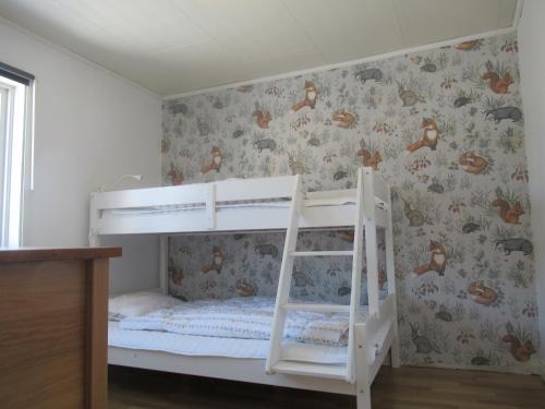 a white bunk bed in a room with wallpaper at Villa Indalsälven in Hammarstrand