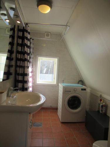 a bathroom with a sink and a washing machine at Villa Indalsälven in Hammarstrand