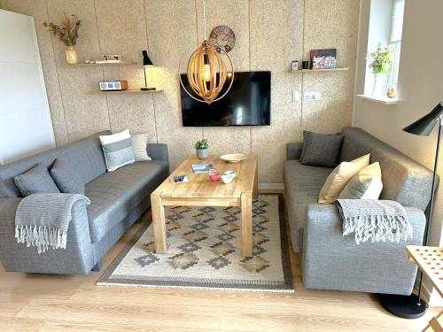 a living room with a couch and a table at Ferielejligheden Bogense Strand / Holiday apartment Bogense Beach in Bogense