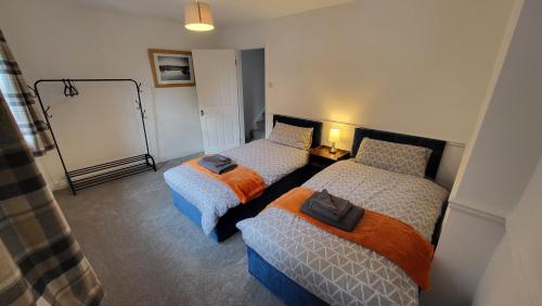 a room with two beds and a mirror in it at Heart of Lincoln City 3 bedrooms sleeps 4 guests in Lincoln