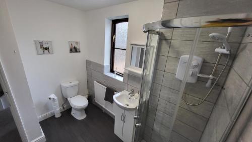 a bathroom with a shower and a toilet and a sink at Heart of Lincoln City 3 bedrooms sleeps 4 guests in Lincoln