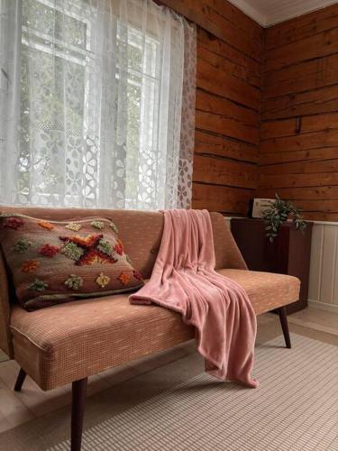 a couch sitting in a room with a window at Mamma maja in Kiviõli