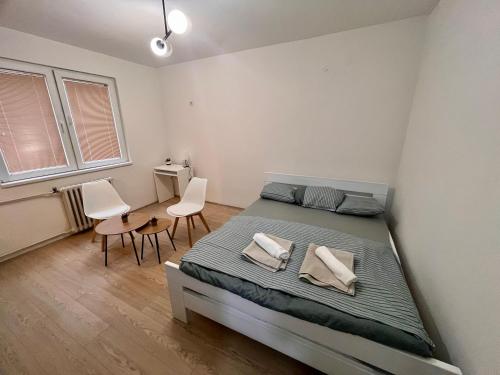 1 dormitorio con 1 cama grande y 2 sillas en Roosevelt apartment, en Skopje