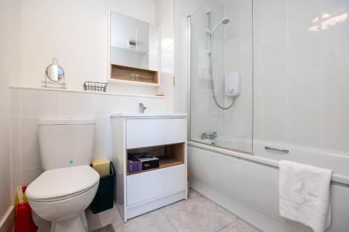 a white bathroom with a toilet and a shower at Flat w/ Balcony & Canal view - 4min to station in Dublin
