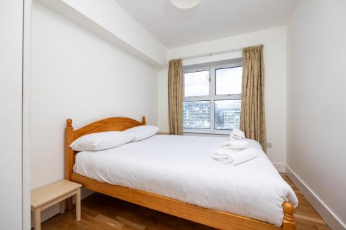 1 dormitorio con cama y ventana en Flat w/ Balcony & Canal view - 4min to station, en Dublín