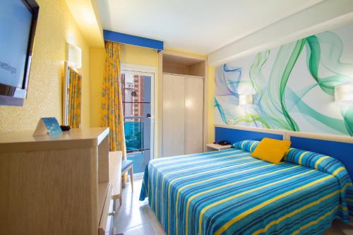 una camera da letto con un letto e un dipinto sul muro di Hotel Servigroup Rialto a Benidorm