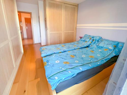 a bed with a blue comforter in a bedroom at Lovely home - Free parking in Budapest