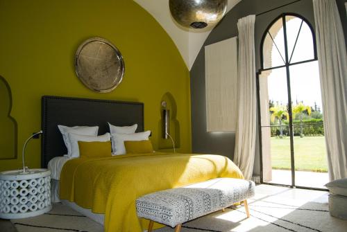 - une chambre avec un lit jaune et une fenêtre dans l'établissement Palais Laawina, à Marrakech